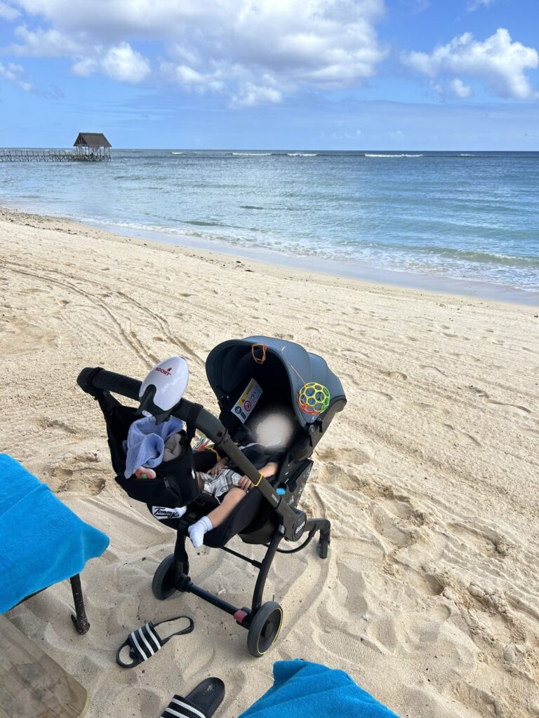 Baby im Reisebuggy am Strand, Doona X 